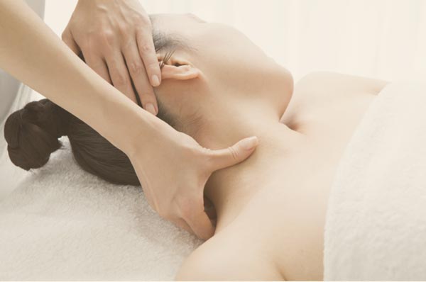 client receiving a signature massage, focusing on neck and shoulder area